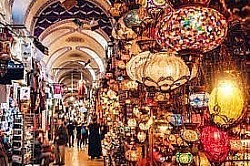Kapalıçarşı.İstanbul’un tarihi ve renkli çarşısı Kapalıçarşı, İstanbul’un zenginliklerini izlemek için adım attığınız anda sizi büyüler. 15. yüzyılda Osmanlı İmparatorluğu tarafından yapılan dünyanın en eski ve kapalı çarşılarından biridir. Kapalıçarşı’da, kendinizin bir zaman yolculuğunda hissedersiniz. Arnavut kaldırımlı sokaklar, taş yapılar ve tarihi dükkanlar arasında dolaşırken, Osmanlı İmparatorluğu'nun eski günlerine tanık olacaksınız.  Çarşıyı gezerken tarihin atmosferini ve zengin kültürel geçmişini keşfedebilirsiniz. Kapalıçarşı, her türlü ürünün bulunduğu bir alışveriş cennetidir. Koleksiyon dükkanları arasında kaybolabilir ve takı, halı, deri, tekstil, antika, gümüş, altın, el yapımı süs eşyaları gibi çeşitli ürünleri keşfedebilirsiniz. Kapalıçarşı, pazarlık kültürünün yaşadığı canlı bir yer. Dükkanlarda satıcılarla pazarlık yapabilir ve fiyatı daha uygun hale getirebilirsiniz. Pazarlık yaparken hünerli olun ve eğlenceli bir deneyim yaşayın.  Açık olduğu saatler: Dini tatiller, Cumhuriyet Bayramı ve pazar günleri kapalıdır. Diğer günler 08:30-19:00 saatleri arasında açık............................................................... Beyazıt, 34126 Fatih/İstanbul